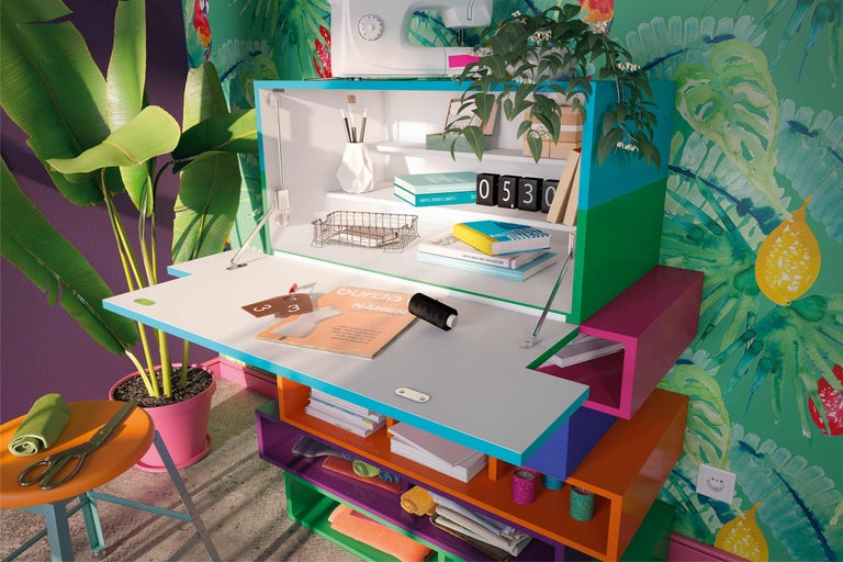 Armoire de bureau avec surface de travail rabattable, étagères et objets de décoration dans une pièce avec du papier peint tropical
