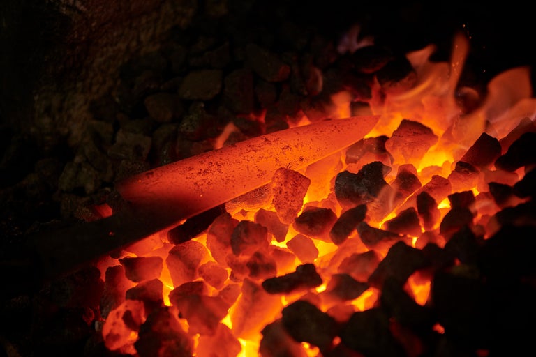 Pièce de métal rougeoyante dans du charbon