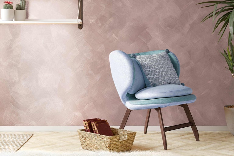 Salon avec fauteuil, coussins et décoration sur étagère et au sol