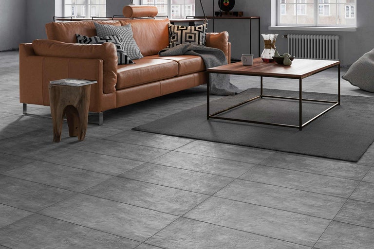 Wohnzimmer mit Ledersofa, Couchtisch und Bodenfliesen