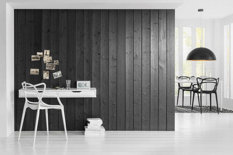 Pièce lumineuse avec lambris en bois noir, bureau et chaise