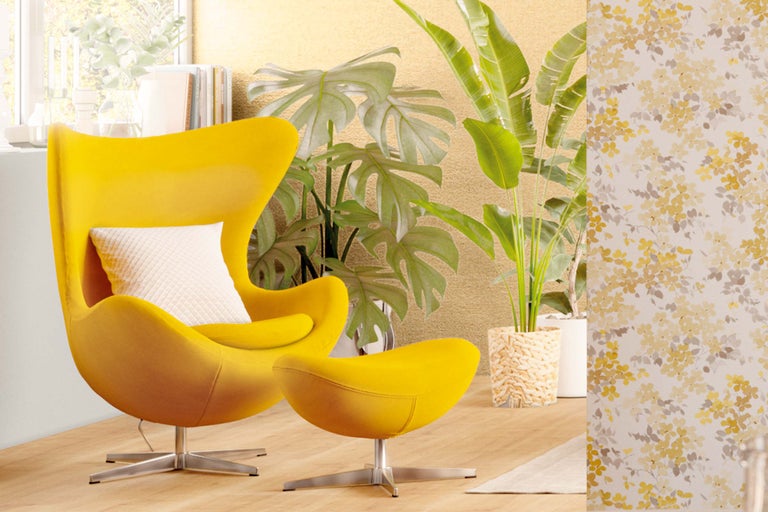 Gelber Sessel mit Hocker und floraler Tapete im Raum