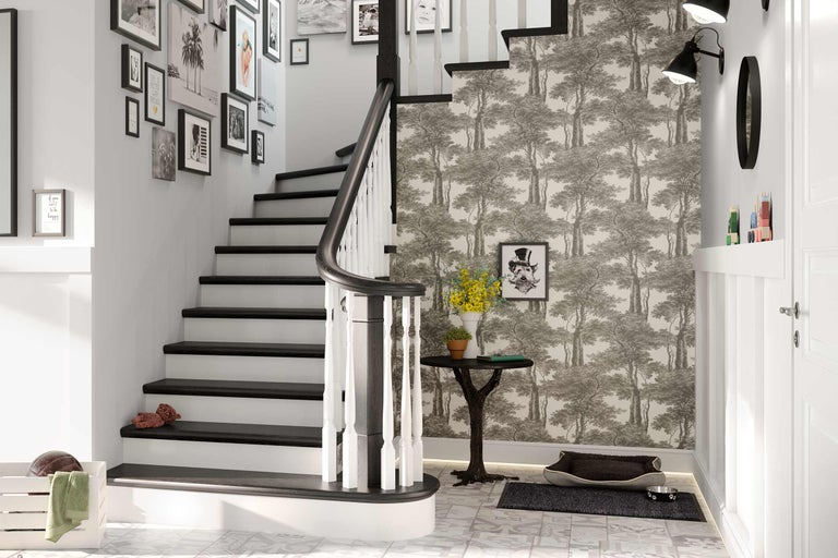 Couloir avec escalier, décoré de papier peint, de tableaux et d'accessoires.