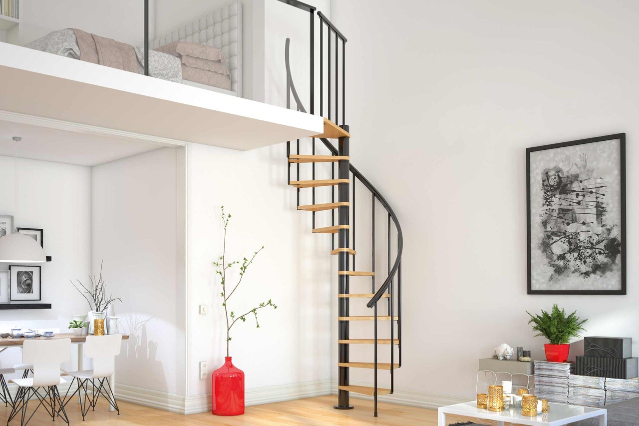 Salon lumineux avec un escalier en colimaçon menant à un lit mezzanine.