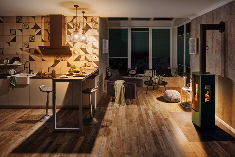 Espace de vie avec cuisine, coin salon, poêle à bois et plancher en bois