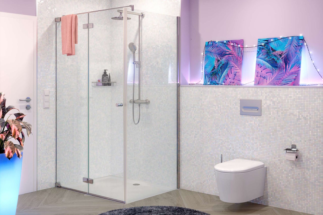 Modernes Badezimmer mit gläserner Duschkabine, Regendusche, wandhängendem WC und hellen Mosaikfliesen.