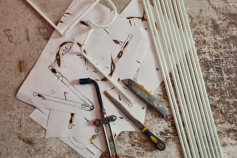 Feuilles de croquis, outils et tubes sur un plan de travail