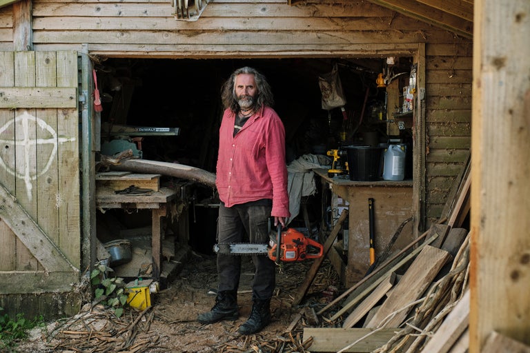 Homme avec une tronçonneuse Husqvarna devant un atelier