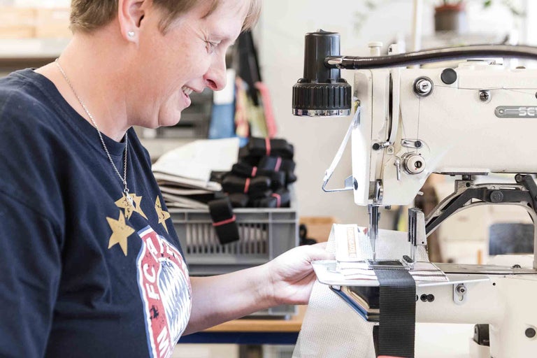 Femme travaillant sur une machine à coudre industrielle sur un produit textile