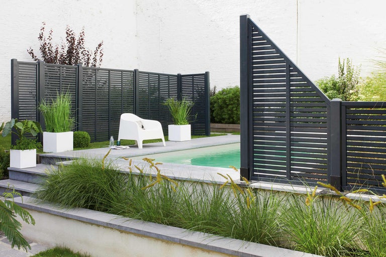 Jardin avec piscine et clôture de protection visuelle en bois