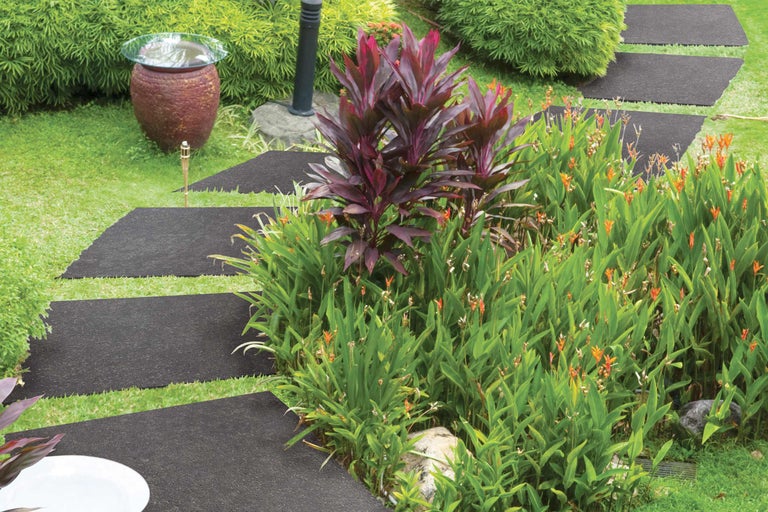 Gartenweg aus Bodenplatten zwischen Grünpflanzen