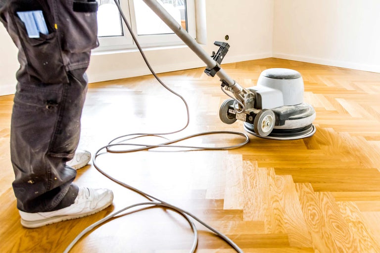 Machine de nettoyage de sol polissant un parquet en bois.