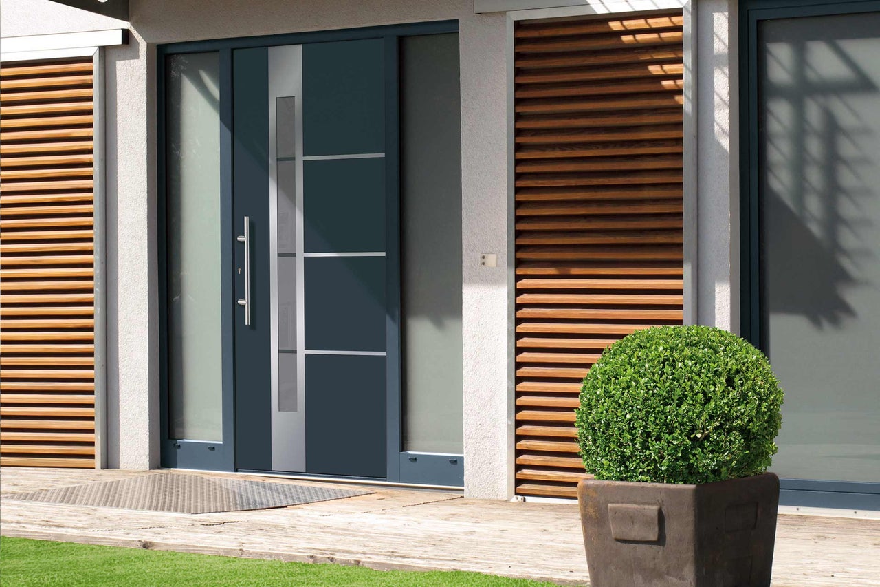 Porte d'entrée moderne avec éléments en verre et poignée en acier inoxydable dans une maison lumineuse