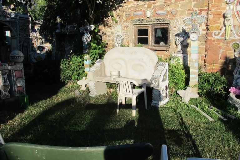 Jardin avec banc décoratif, chaise et mur en mosaïque