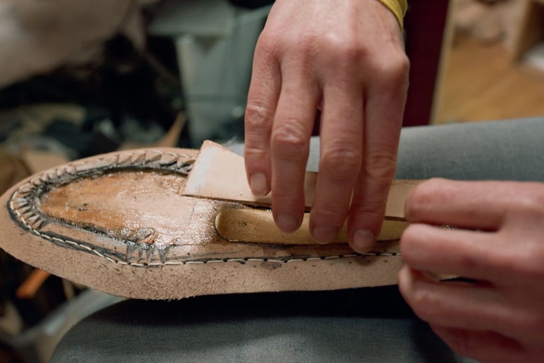 Gros plan sur la réparation d'une semelle en cuir avec des outils