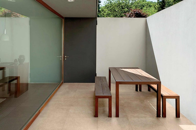 Espace extérieur avec table en bois et bancs en bois sur sol carrelé