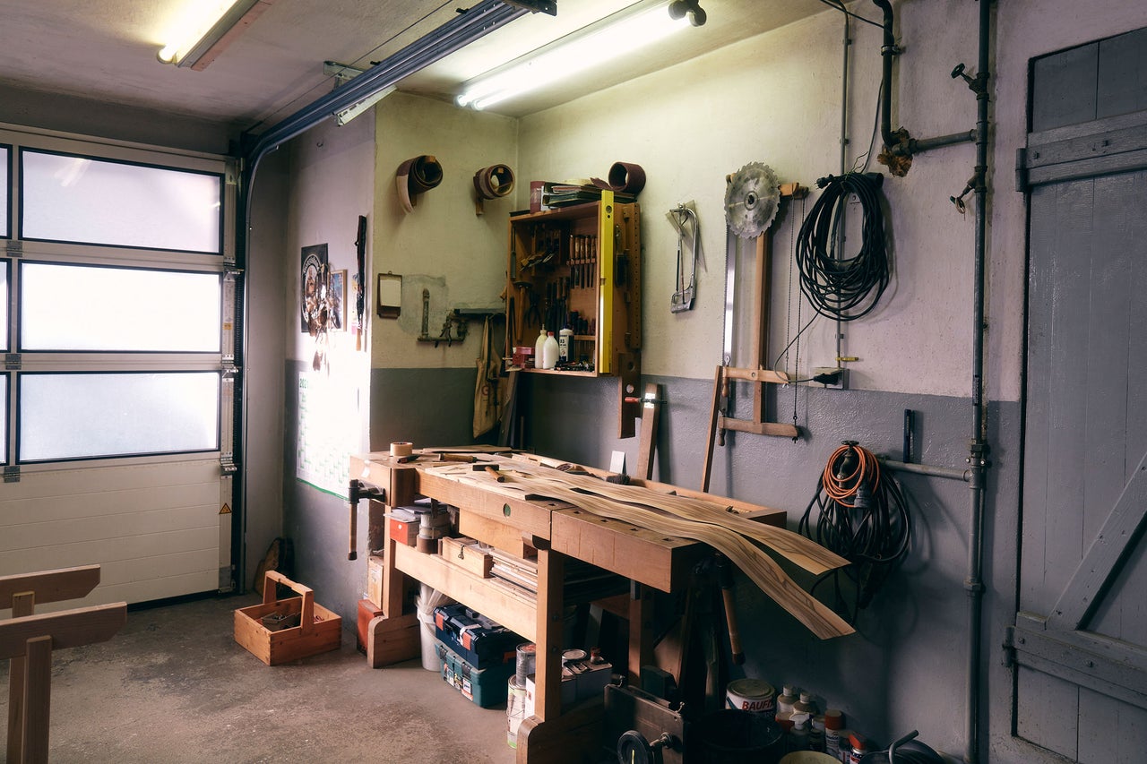 Werkstatt mit Werkbank, Werkzeugen und Holzbalken