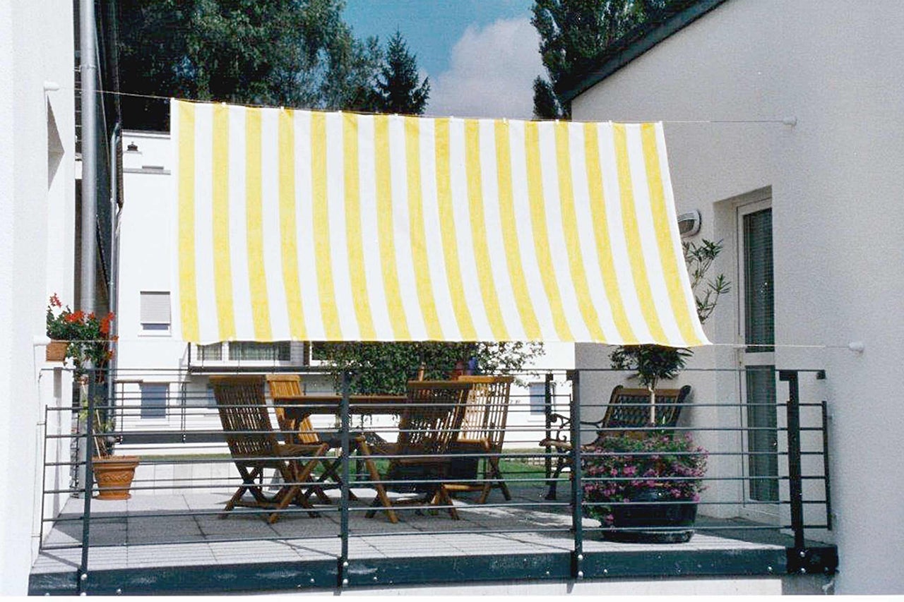 Balkon mit Markise, Tisch und Stühlen für den Außenbereich.