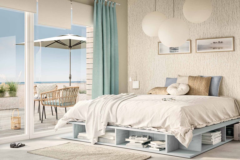 Helles Schlafzimmer mit niedrigem Bettgestell mit Stauraum, Vorhängen und Terrassenzugang mit Gartenmöbeln