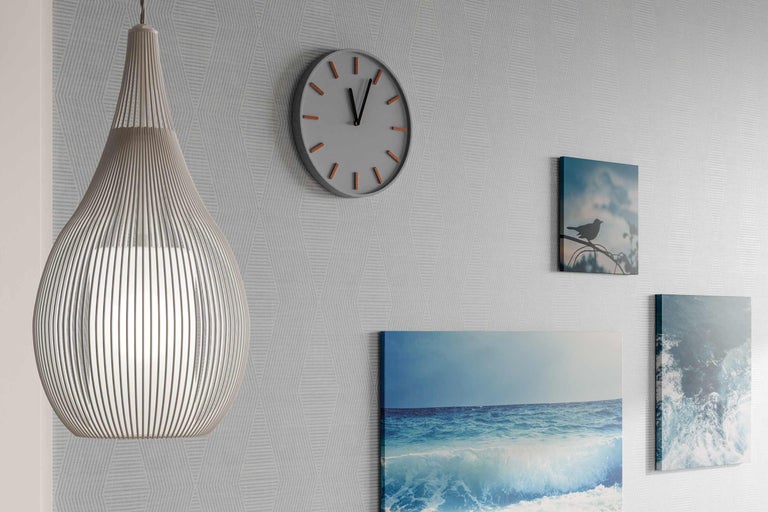 Raumansicht mit Pendelleuchte, Wanduhr und Bildern