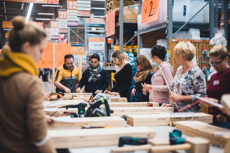 Des personnes travaillent le bois et utilisent des outils électriques dans un magasin de bricolage.
