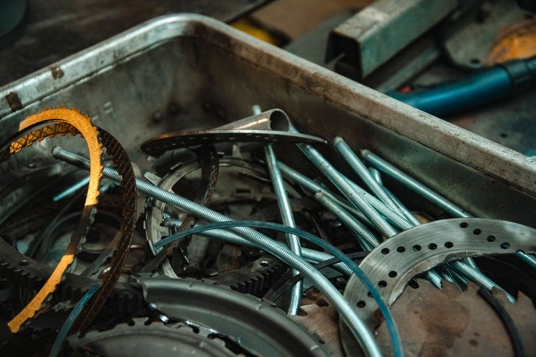 Une boîte en métal remplie de vis, d'écrous, d'engrenages et de tiges métalliques