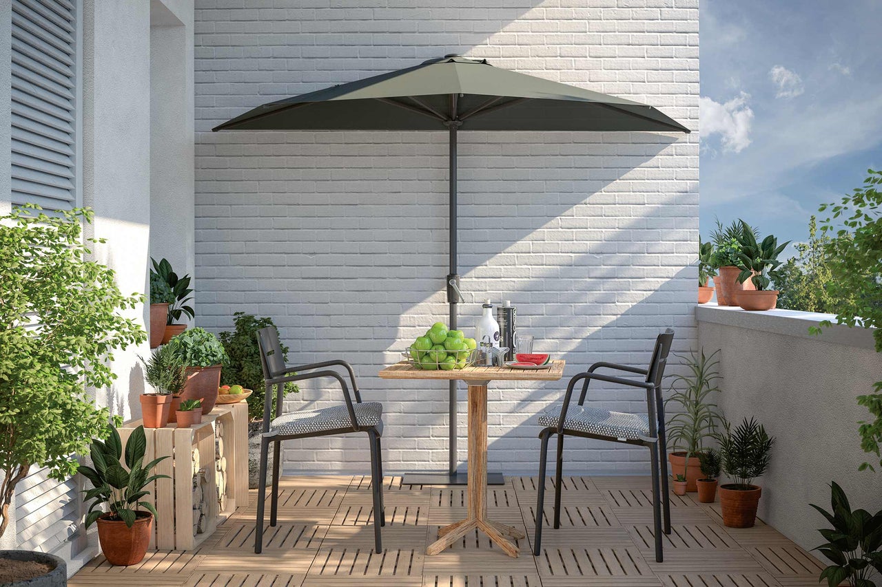 Balkon mit Sonnenschirm, Tisch und Stühlen auf Holzboden
