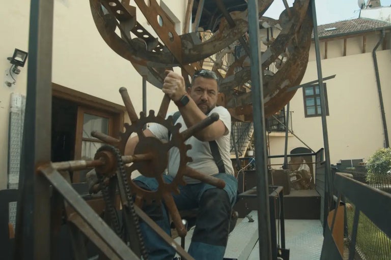 Mann bedient eine große Metallkonstruktion im Außenbereich.