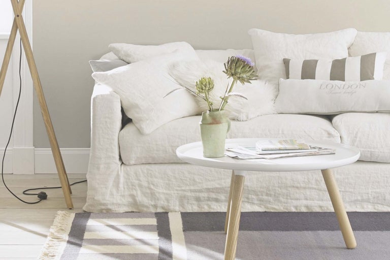 Salon avec canapé blanc, table et lampadaire