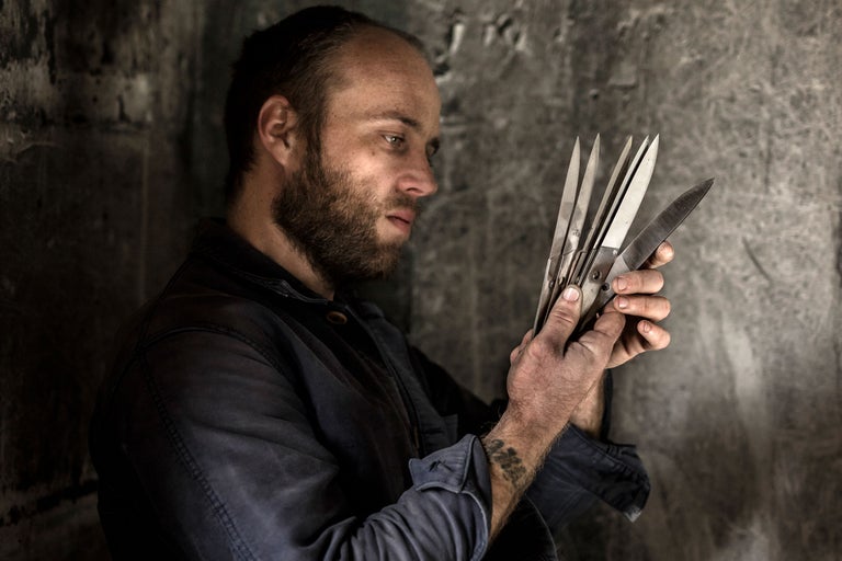 Homme regardant des outils de jardinage, sécateur