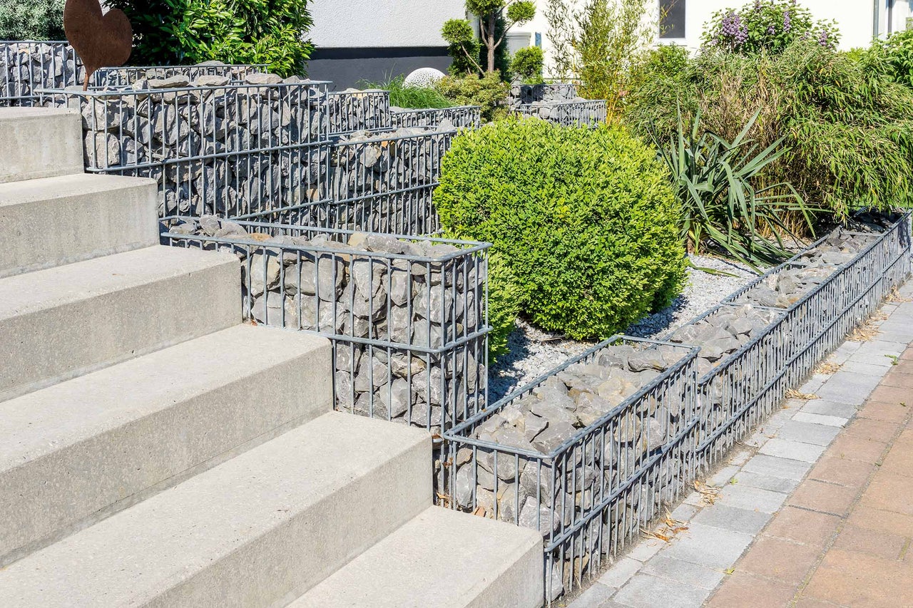 Aménagement paysager de jardin avec des gabions, un escalier en pierre et des plantations