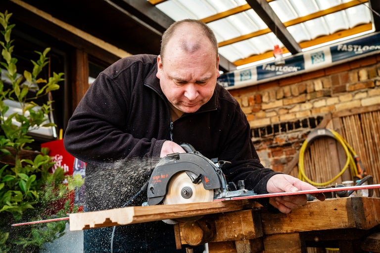 Artisan coupant du bois avec une scie circulaire portative