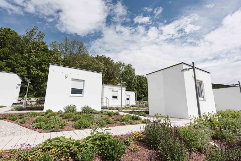 Mehrere weisse Modulhäuser mit Gartenanlage