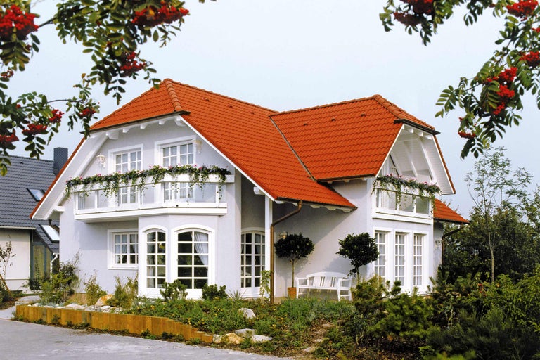Einfamilienhaus mit rotem Ziegeldach und blühenden Balkonen
