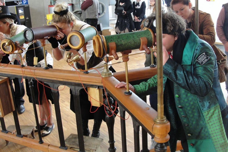 Personnes regardant à travers des télescopes de style steampunk