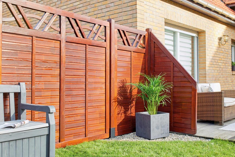Clôture d'intimité en bois avec élément décoratif et banc de jardin dans le jardin