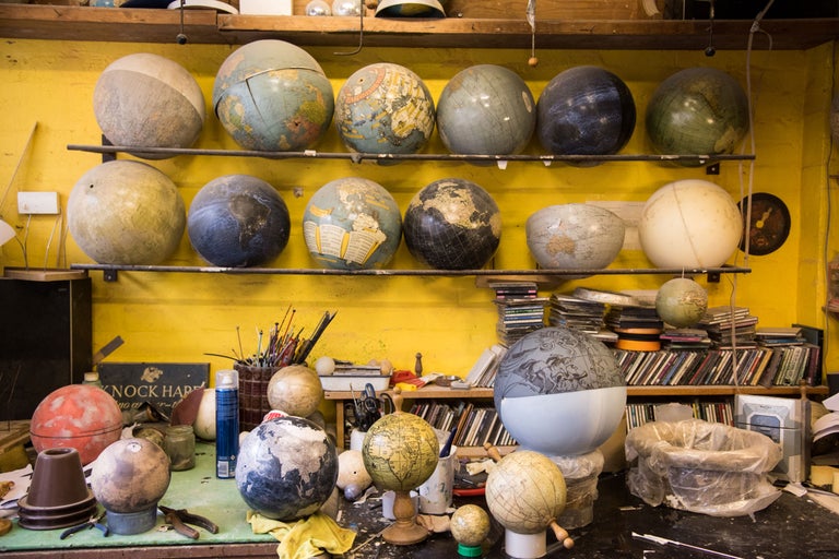 Vue d'un espace de travail avec des étagères et une table remplie de globes