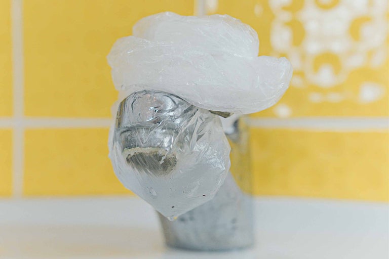 Un robinet est recouvert d'un sac en plastique.