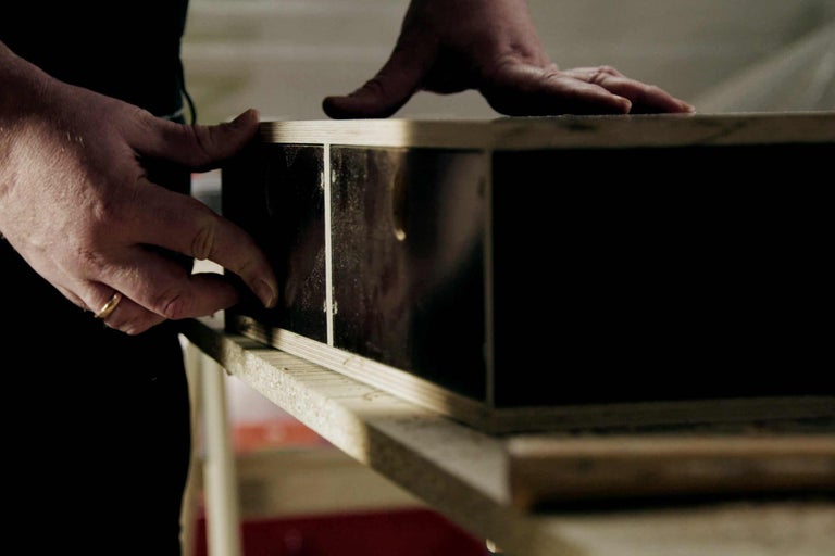 Gros plan d'un homme travaillant sur une structure en bois.