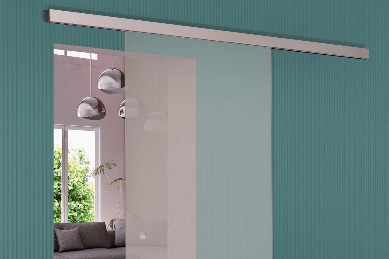 Glastür mit Metallschiene vor einer gemusterten Wand