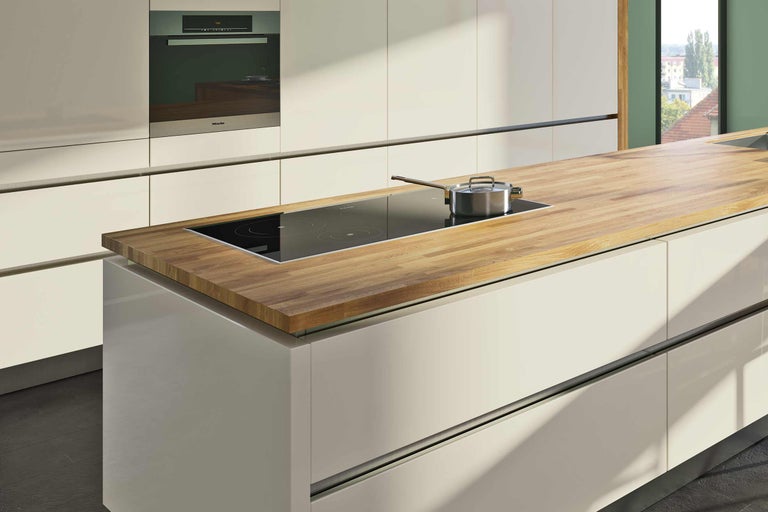 Îlot de cuisine avec plaque à induction, casserole et four Miele intégré