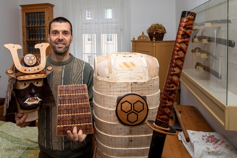 Un homme présente une armure de samouraï japonaise et une épée