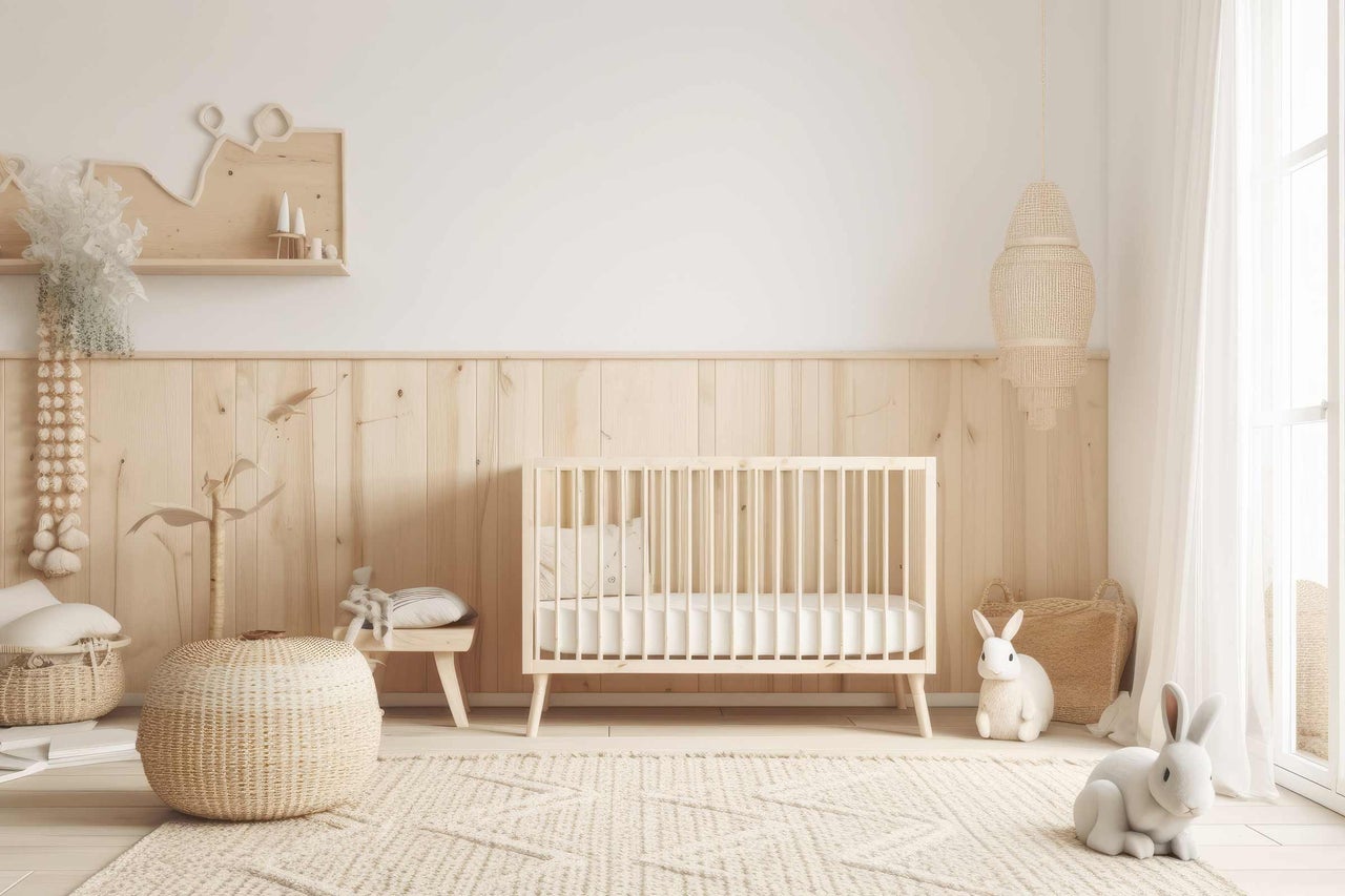 Chambre d'enfant avec lambris en bois, lit à barreaux, tapis et décorations.