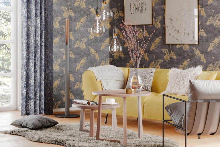 Helles Wohnzimmer mit gelbem Sofa, Holztischen, Stehlampe und gemusterter Tapete