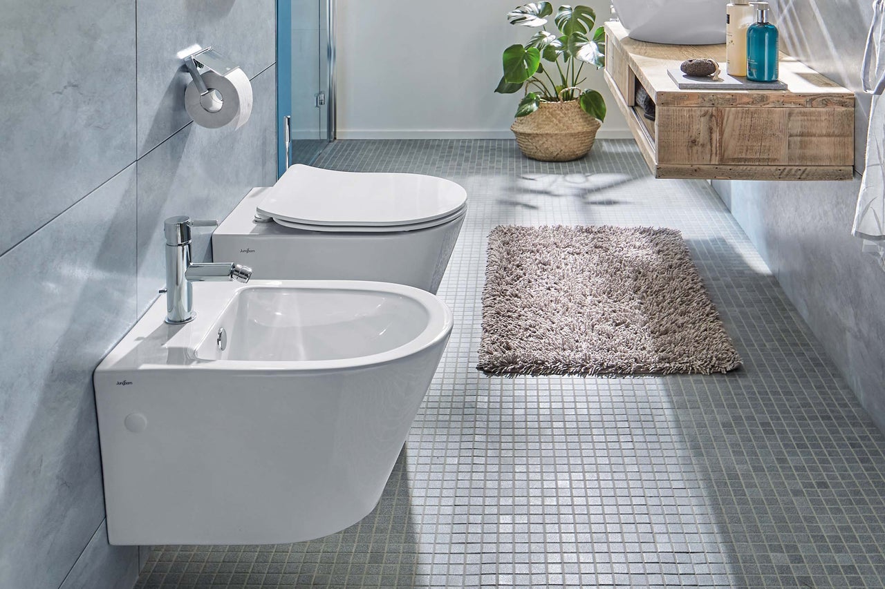Modernes Badezimmer mit Bidet, Toilette, Teppich und Holzwaschtisch