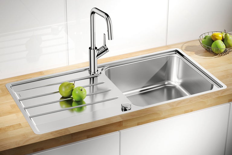 Évier en acier inoxydable avec égouttoir et mitigeur dans une cuisine moderne