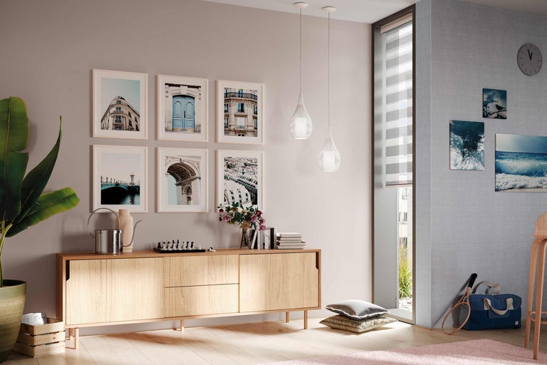 Salon avec commode en bois, tableaux, suspensions et décorations pour une ambiance chaleureuse.