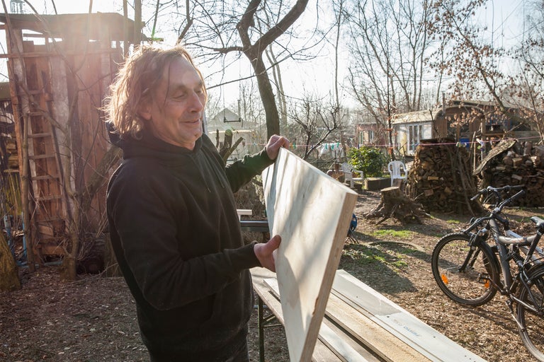 Homme tenant une planche de bois dans le jardin