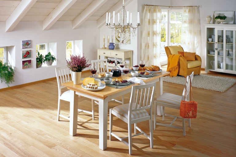 Heller Essbereich mit Holztisch, weißen Stühlen und dekorierter Tafel