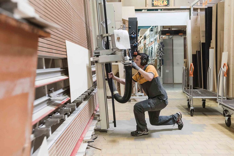 Ein Mann bedient eine Plattenaufteilsäge im Hornbach Holzhandel.